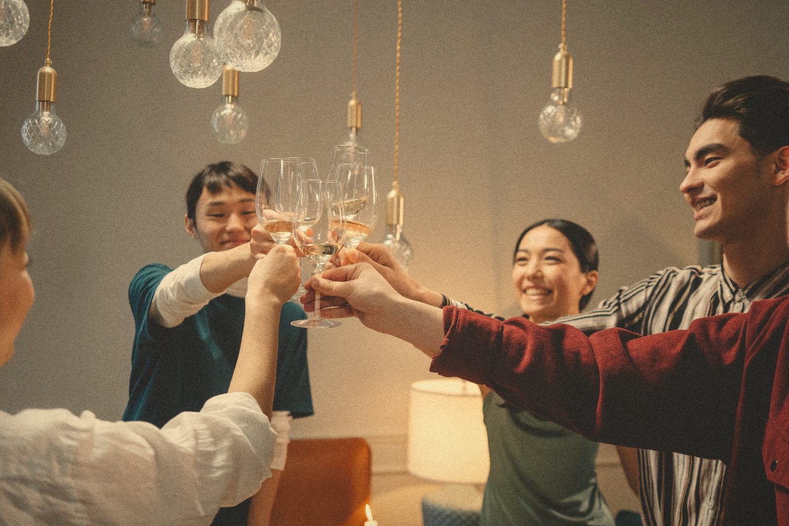 Friends raising their glasses together in a warmly lit living room